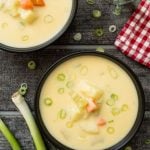 Two servings of German Potato Soup (Kartoffelsuppe). Both creamy potato soup servings are garnished with spring onions.