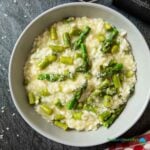 Feature image for asparagus risotto, showing a serving of it, topped with grated parmigiano.