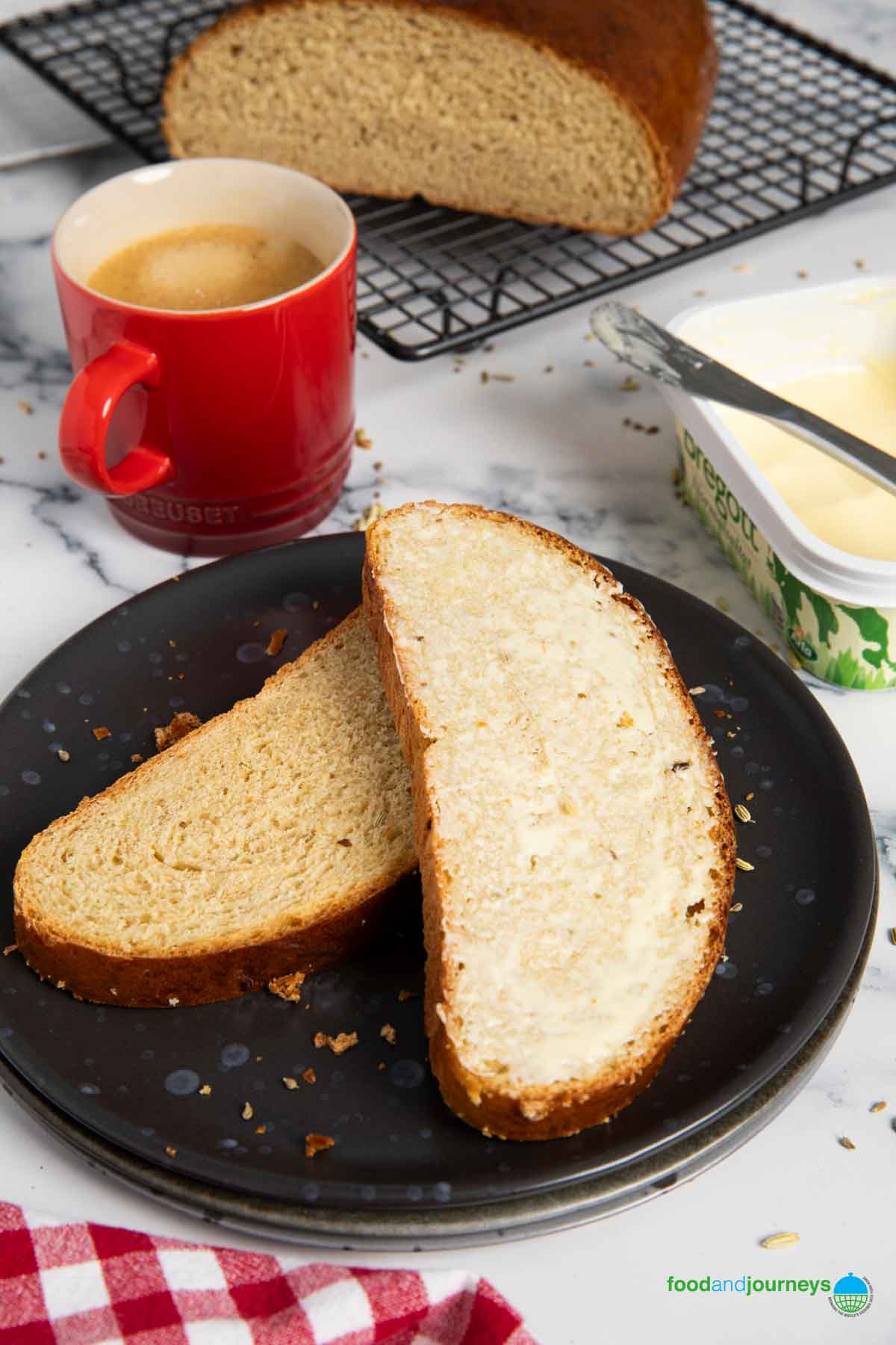 A slice of syrup bread with butter, served with coffee.