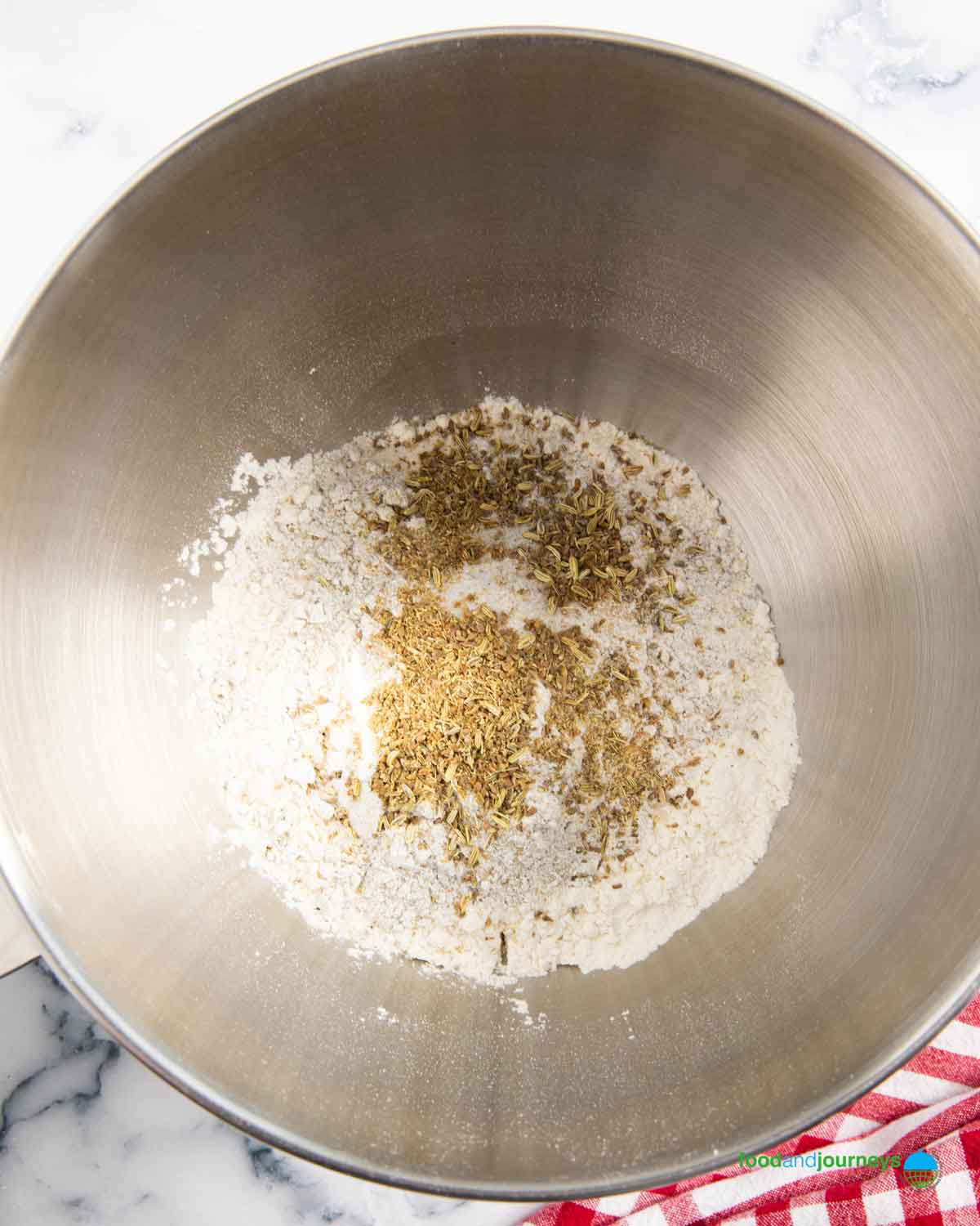 Combining all the dry ingredients for an authentic Swedish limpa bread recipe.