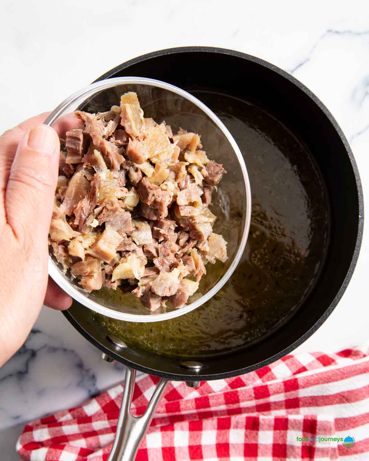 Adding back the chopped oxtail meat in the soup.