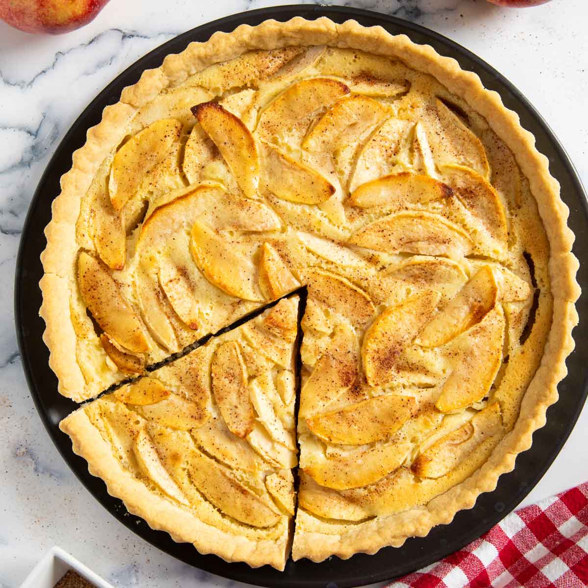 Alsatian apple tart sprinkled with cinnamon and sugar, ready for serving.