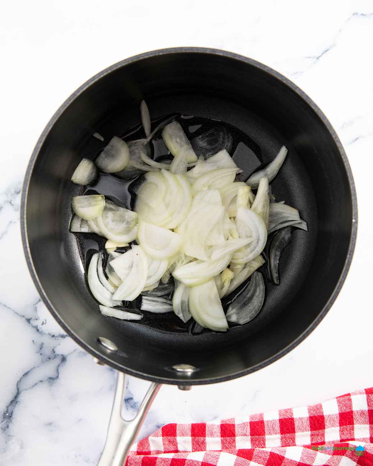 Thinly chopped onion, sautéed with garlic until soft, the first step in making the Filipino soup with mung beans.