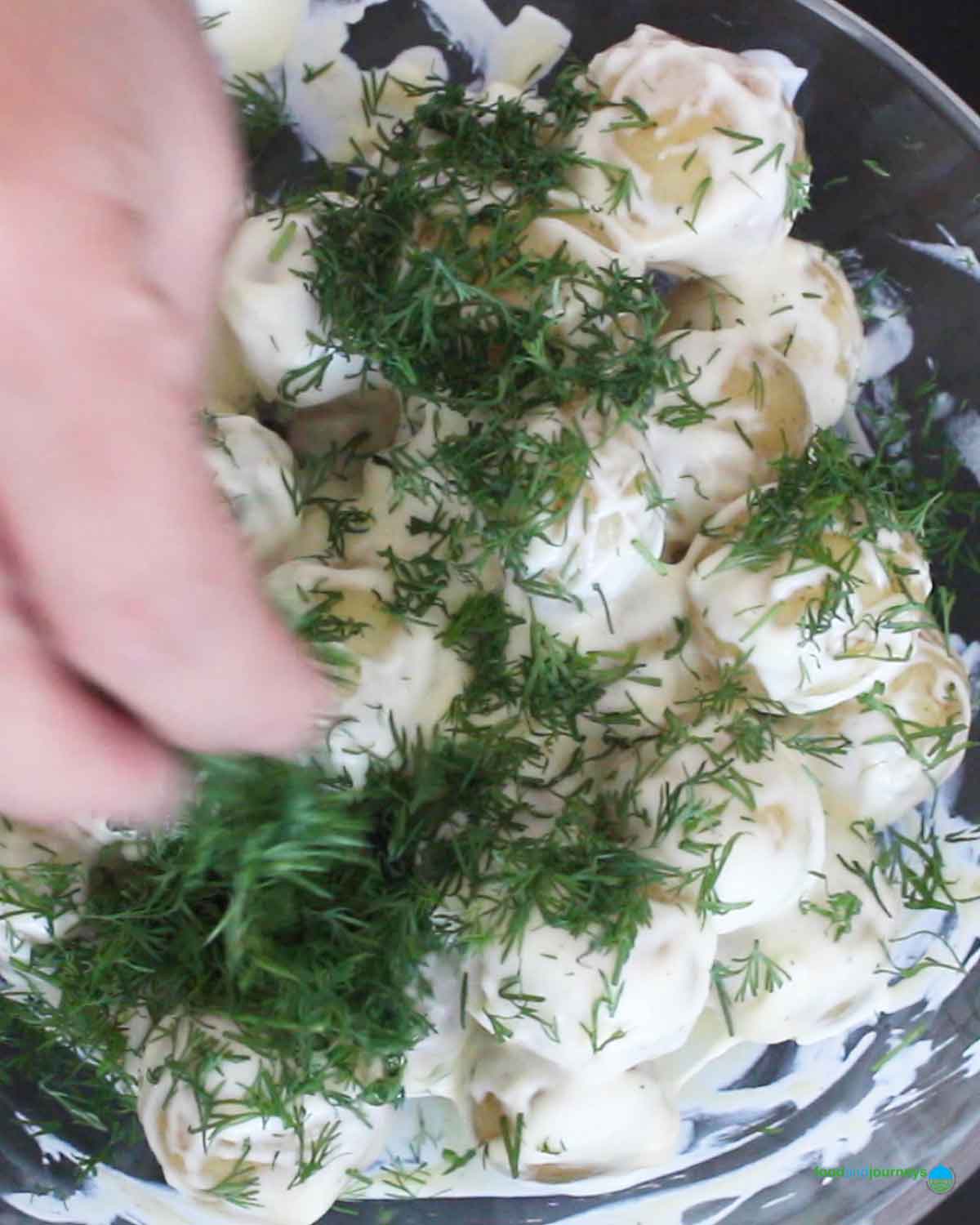 Adding chopped fresh dill as the last step in preparing this creamy Swedish potato dish.