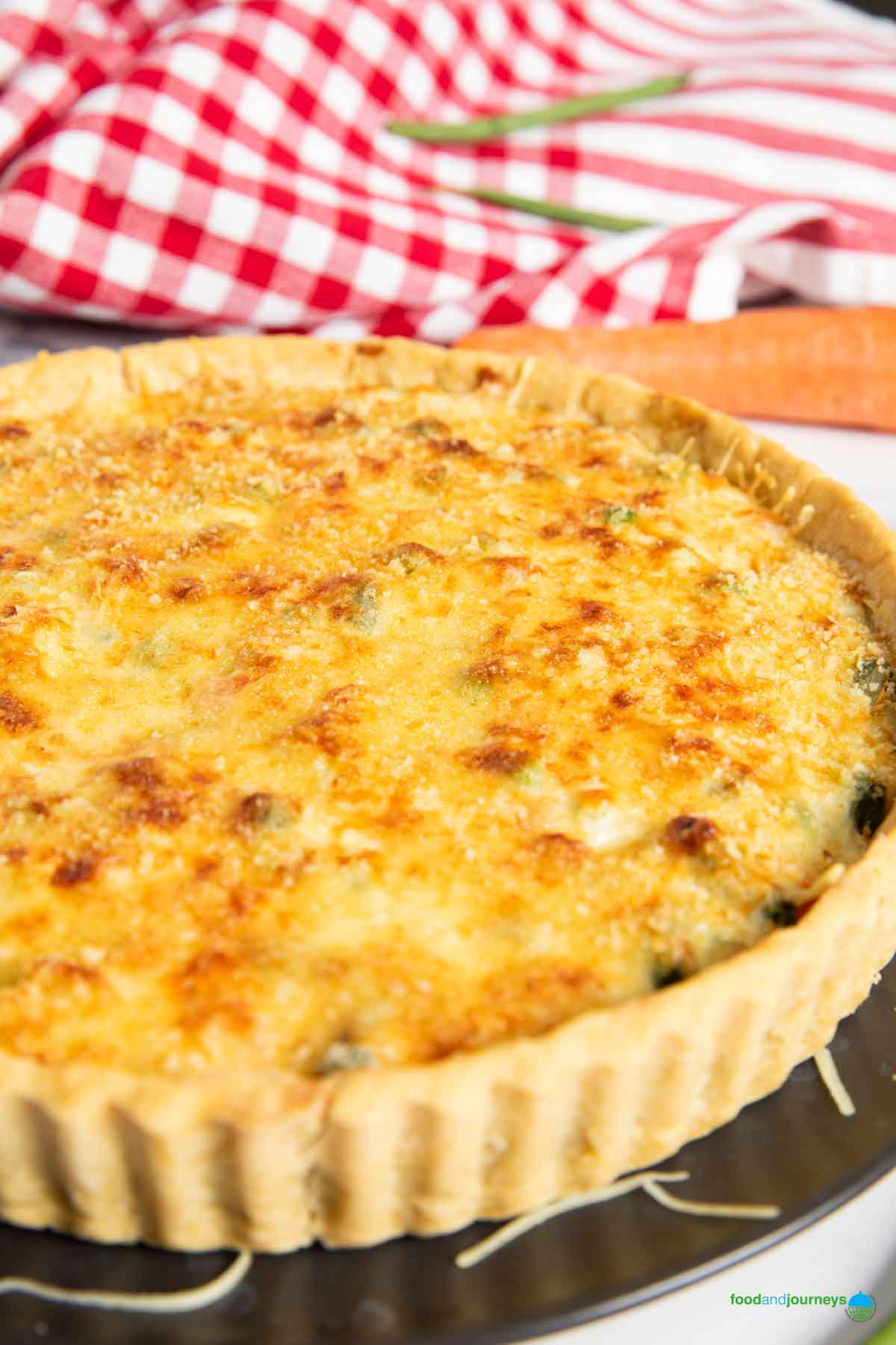 French vegetable tart with its golden and tempting top of grated cheese and breadcrumbs.