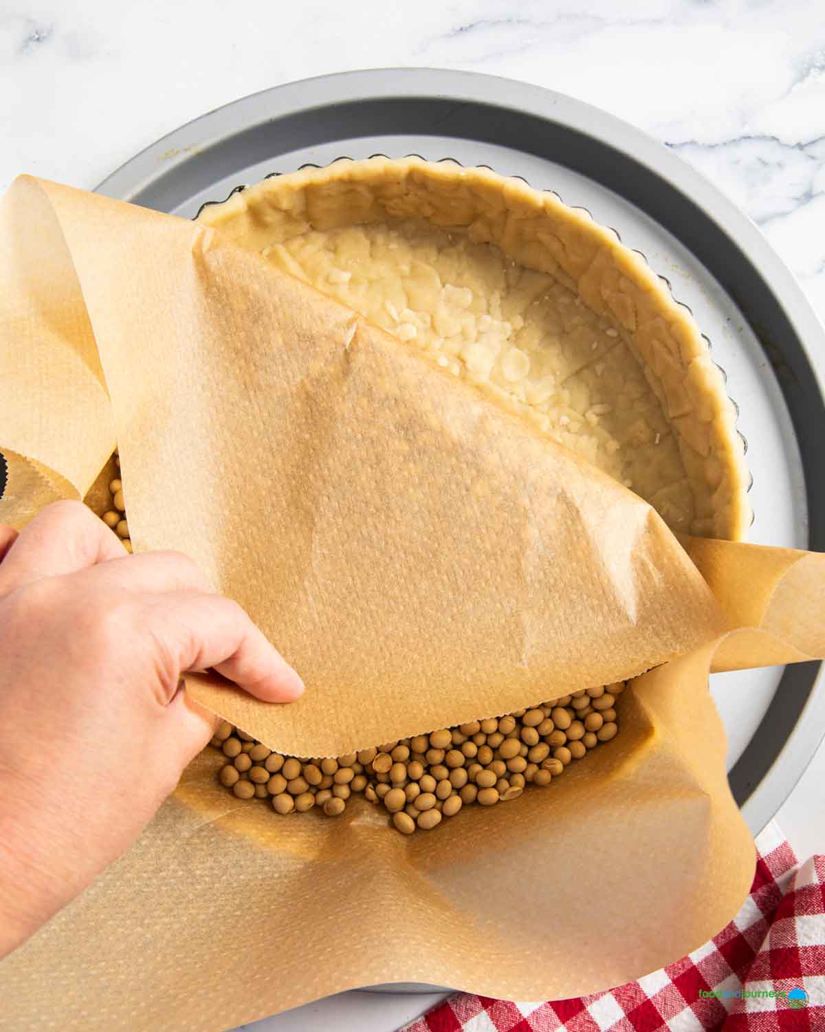 Blind baking the shortcrust pastry is a necessary step for making a traditional vegetable tart from France.