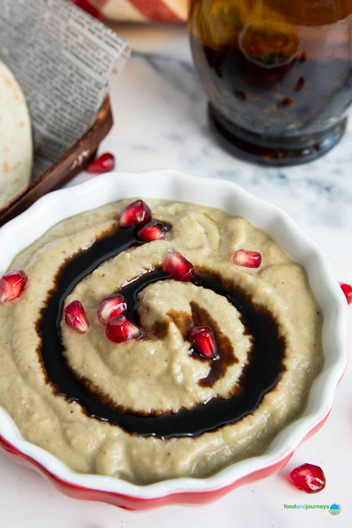 Homemade Lebanese baba ganoush drizzled with pomegranate syrup and served with pita bread.