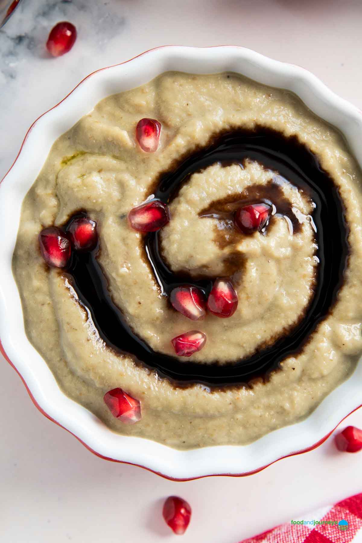 A small bowl of traditional Lebanese baba ganoush with a drizzle of pomegranate syrup.