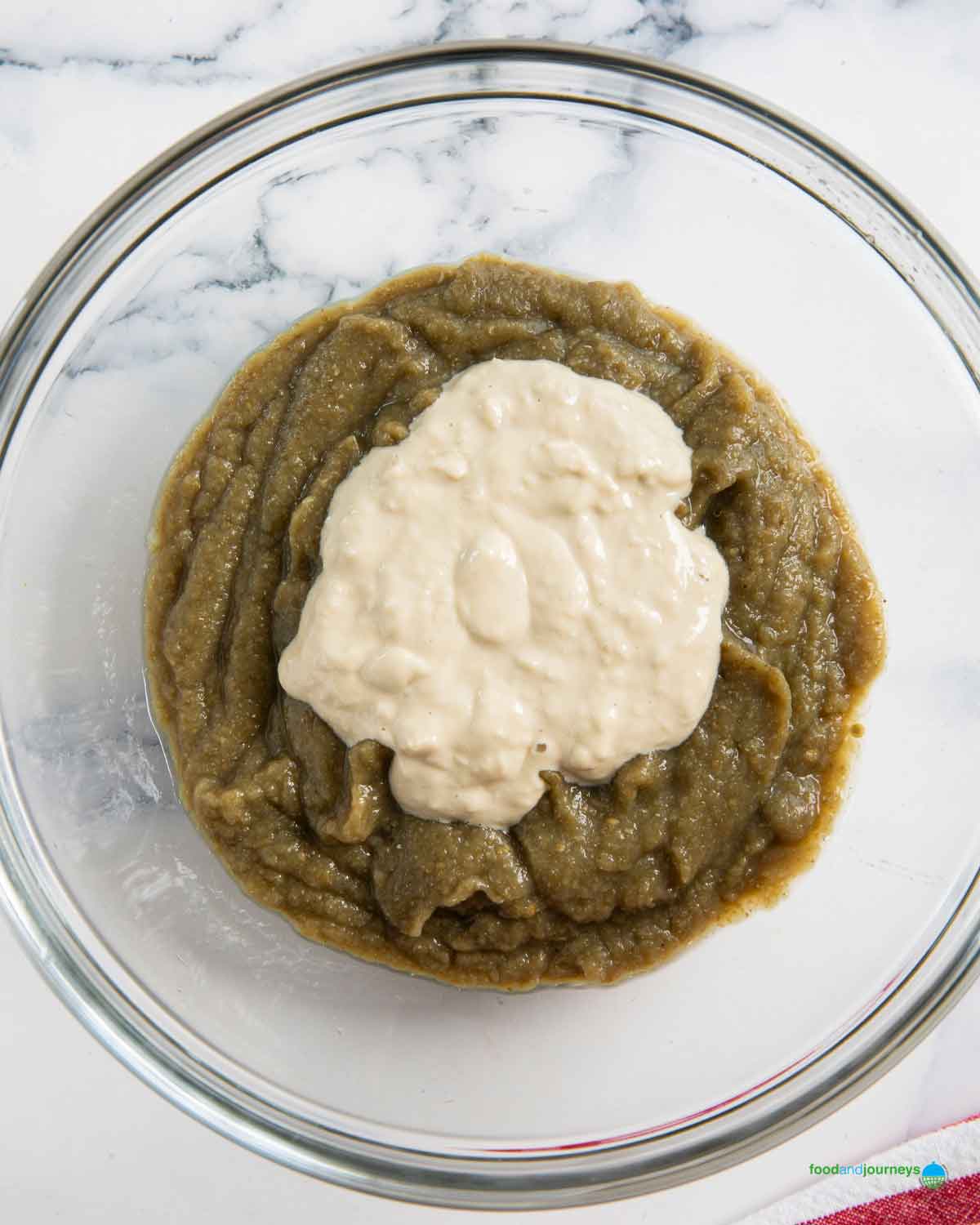 Adding the tahini and garlic paste in the pureed eggplant as the last step in making baba ganoush.