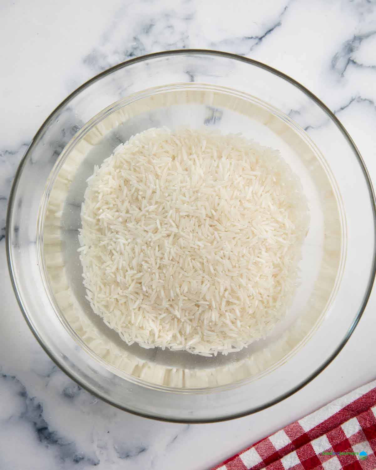 Soaking the rice for a few minutes to remove the starch, crucial to making Mexican yellow rice at home.