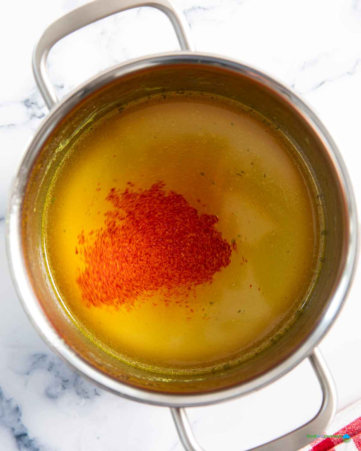 Heating the stock separately for yellow rice, while adding saffron in the process, for the color.
