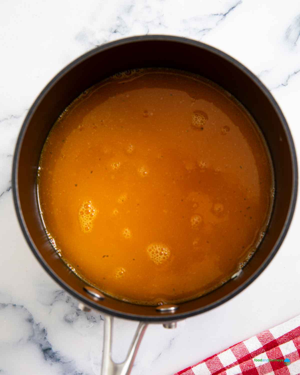 Pouring yellow hot stock into the rice to finish cooking it.