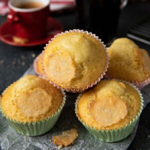 Freshly baked Spanish muffins, served with a cup of espresso in the background.