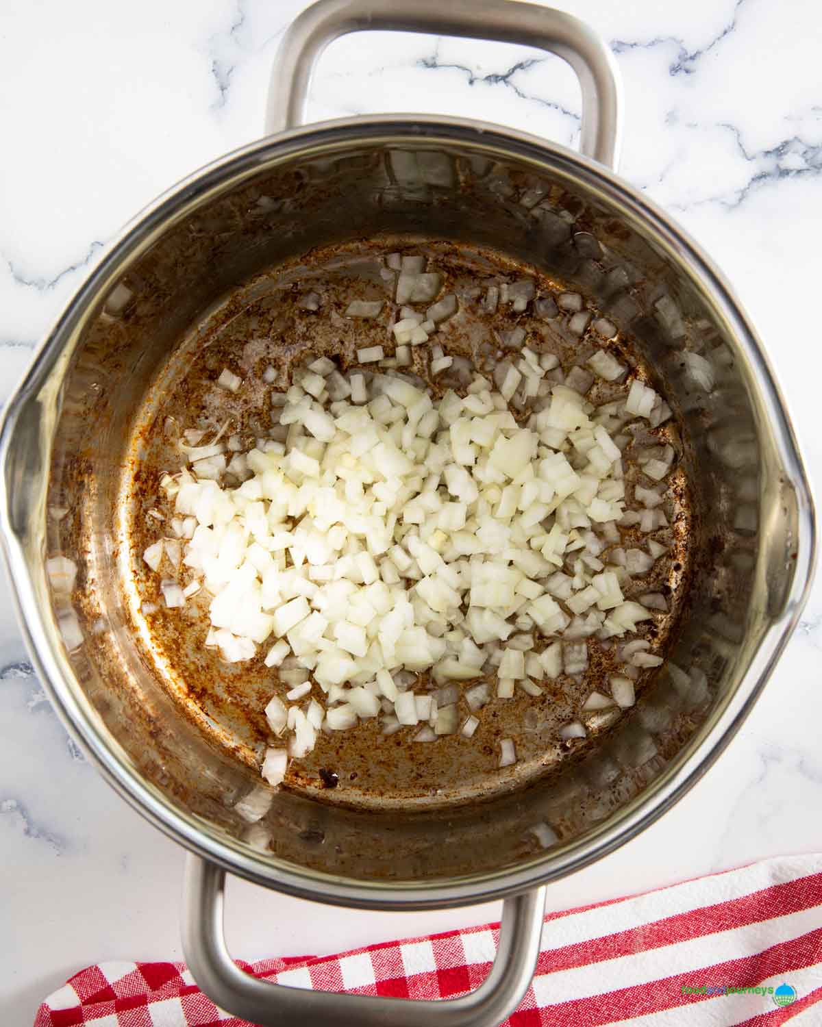 Chopped onions sautéed in a saucepan using oil from bacon for traditional erbsensuppe.