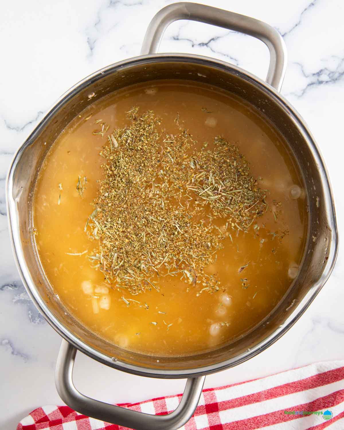 Pouring the cooking liquid from the peas, as well as the softened yellow peas with the rest of the ingredients for erbsensuppe.
