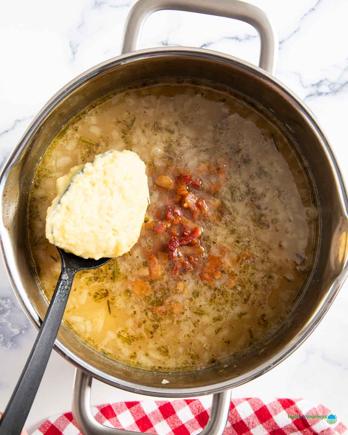 Adding the pureed peas and potatoes back into the soup to add creaminess to the German pea soup.