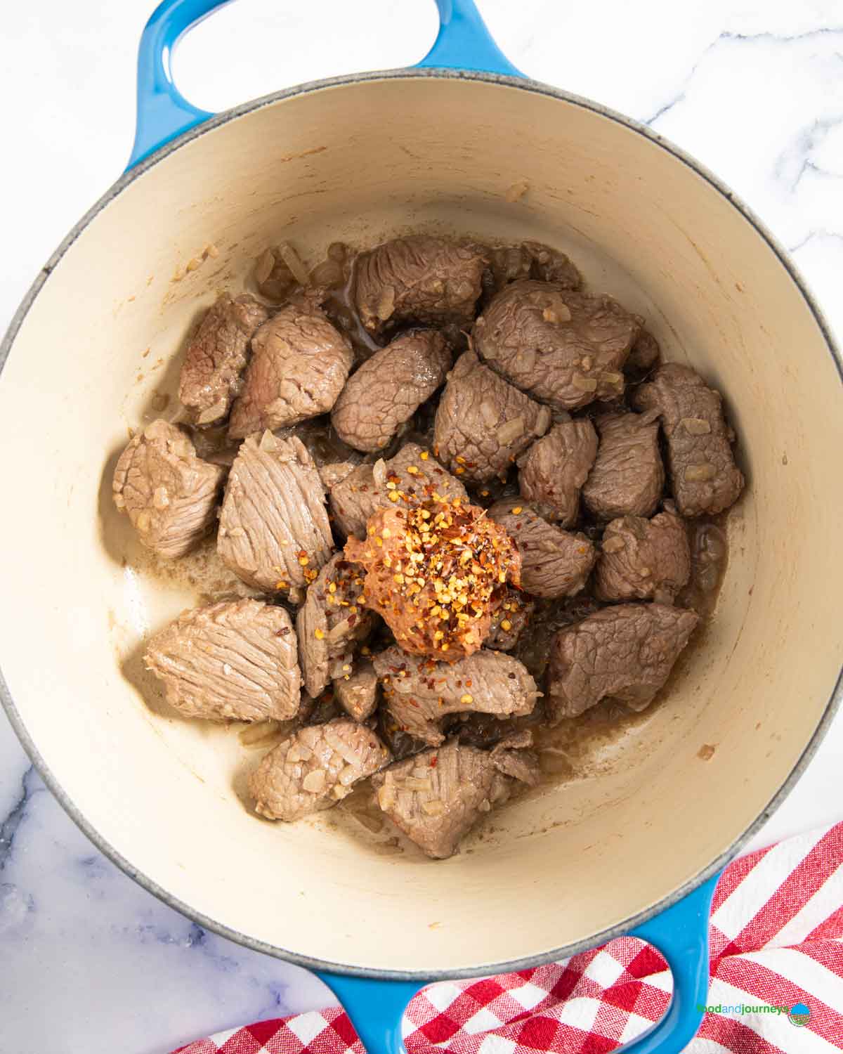 Adding liver spread with a bit of chili flakes for heat, after browning the beef, gives the kaldereta its unique sauce.