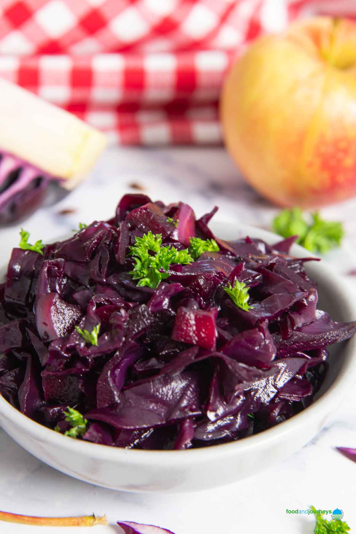 A closer shot of a small serving of rödkål, with an apple in the background.