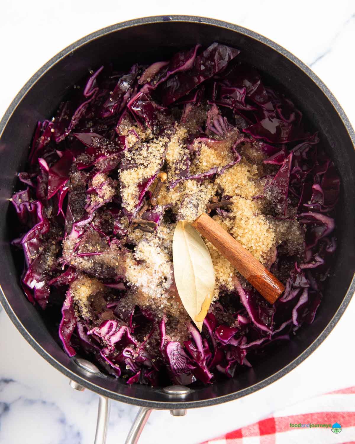 All the ingredients combined with the red cabbage, to start braising it over low heat.