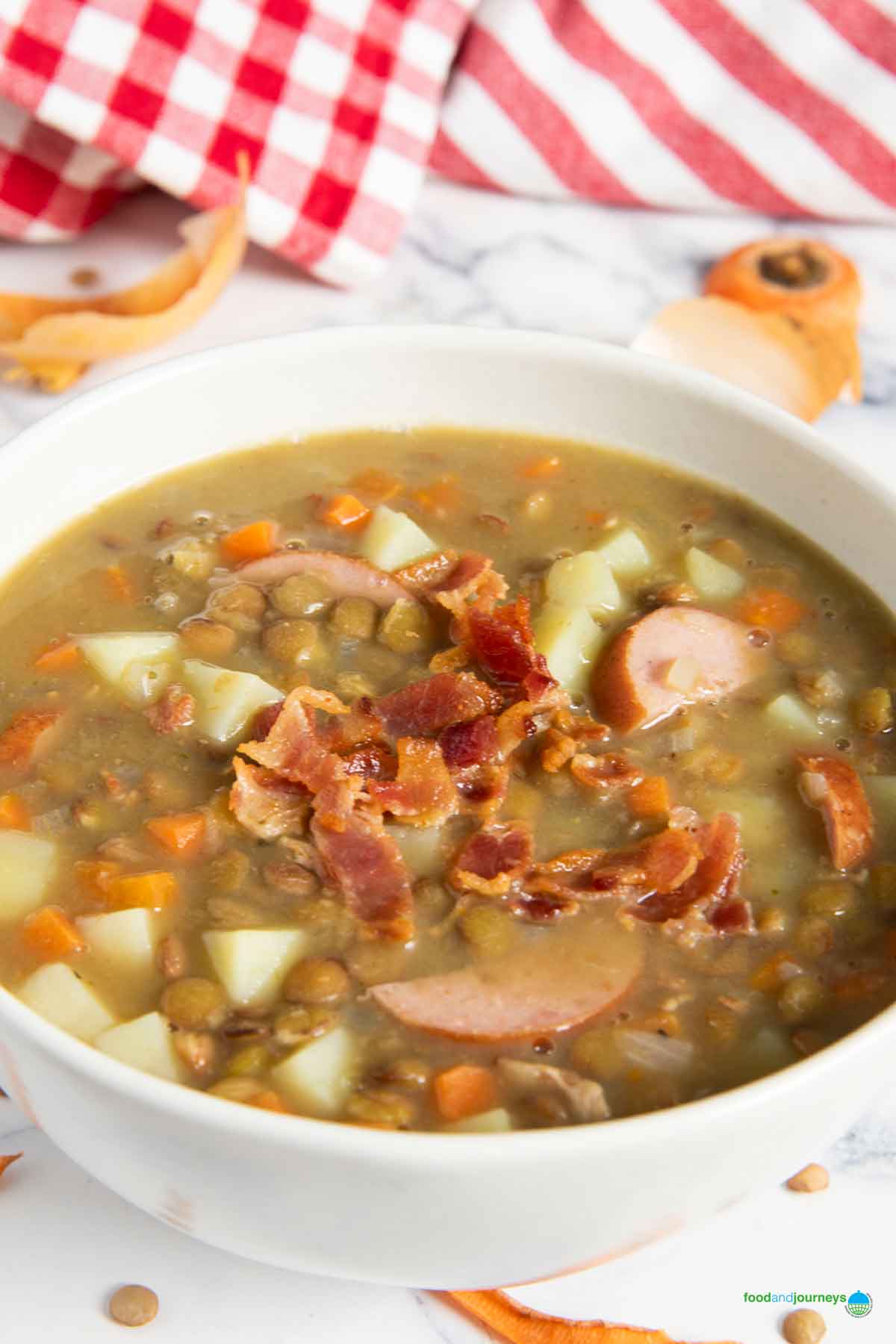 A closer shot of a bowl of linsensuppe, with crispy bacon bits as garnish.
