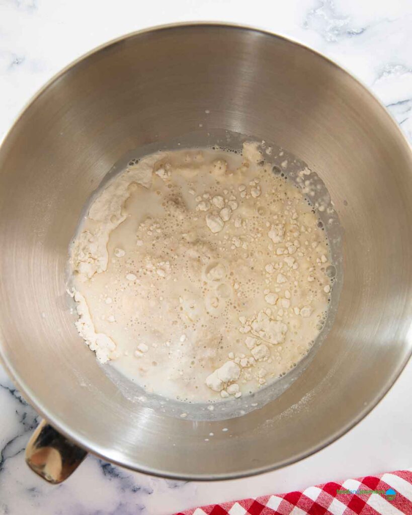 Combing flour with the yeast mixture before mixing and kneading it into a smooth dough for the Lebanese stuffed bread.
