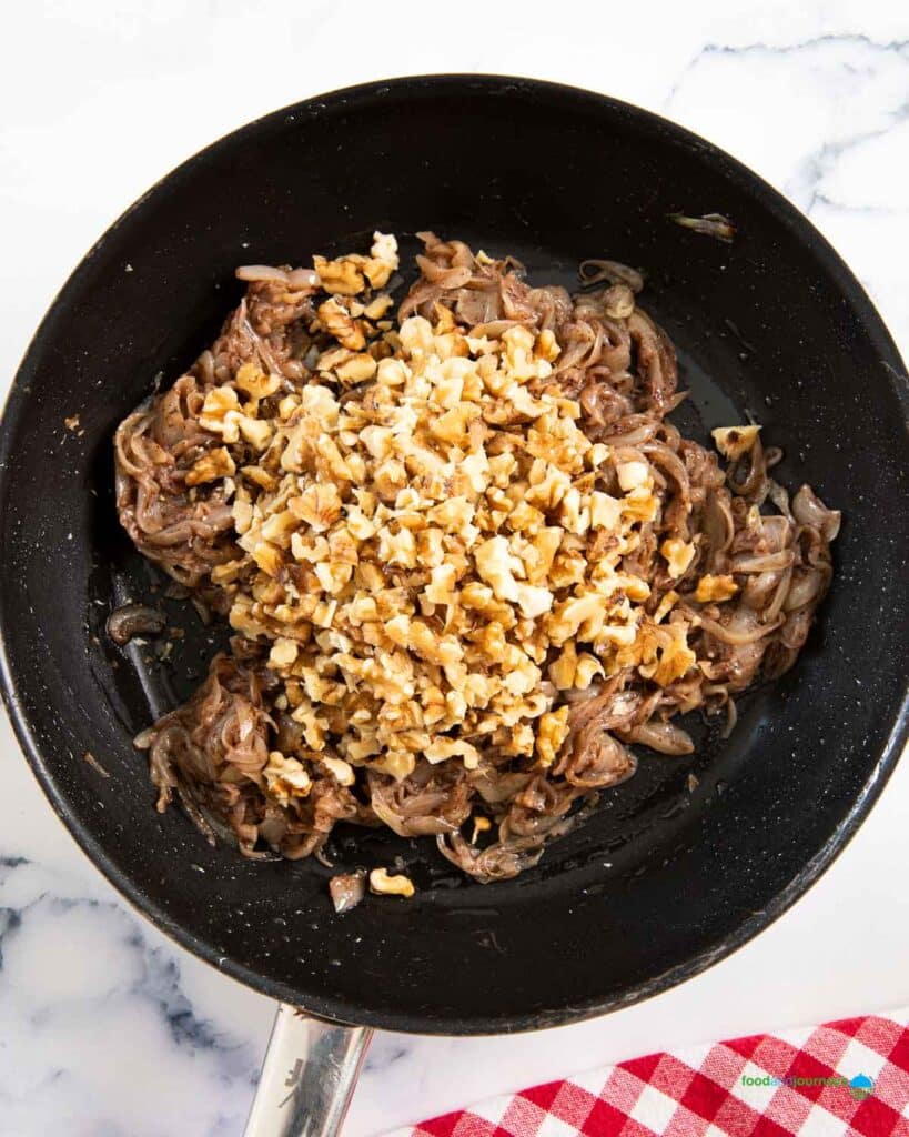 Adding the toasted walnuts as the last step in making the filling for the Lebanese onion bread.